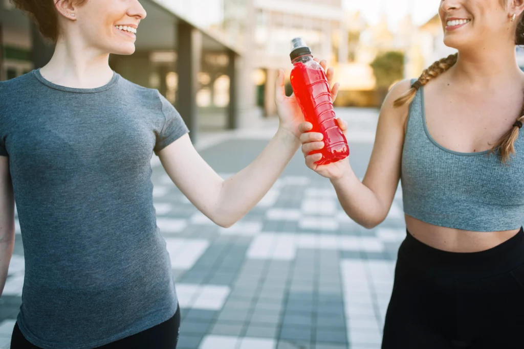 two ladies share a bottle of water